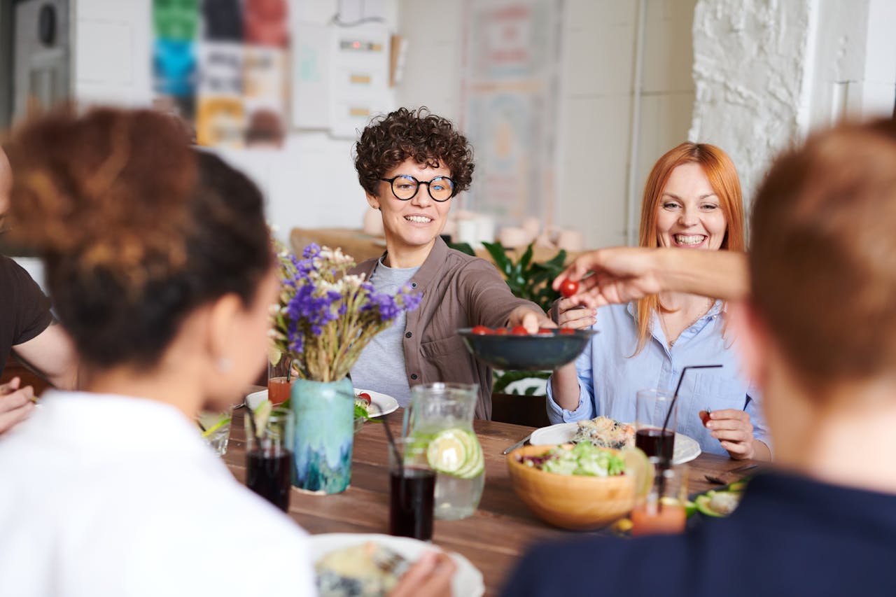 A happy group of friends and family enjoying a meal together indoors. Perfect for themes of togetherness and joy.